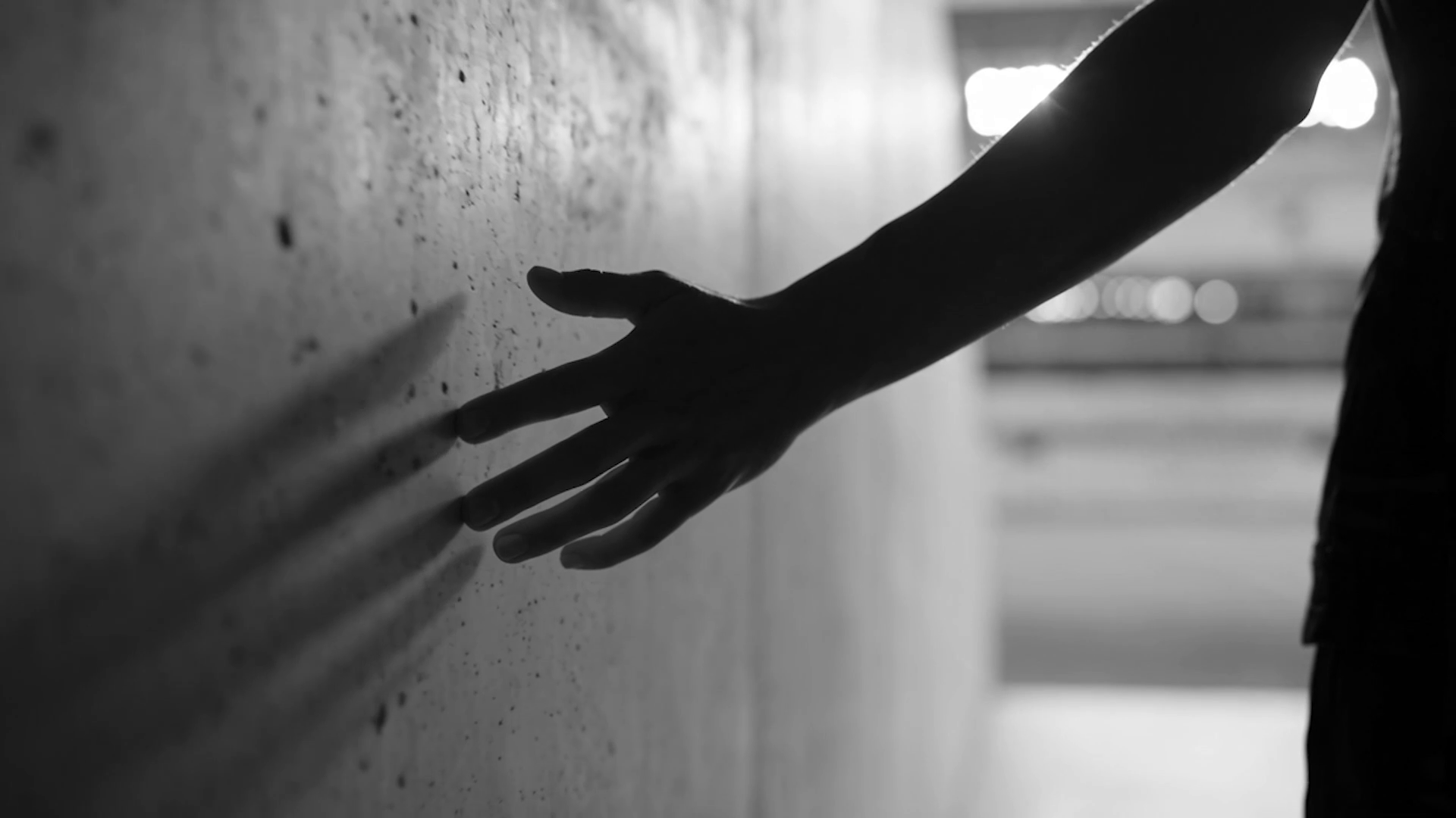 One Touch cover artwork — a silhouetted hand reaching toward a concrete wall, stadium lights beyond